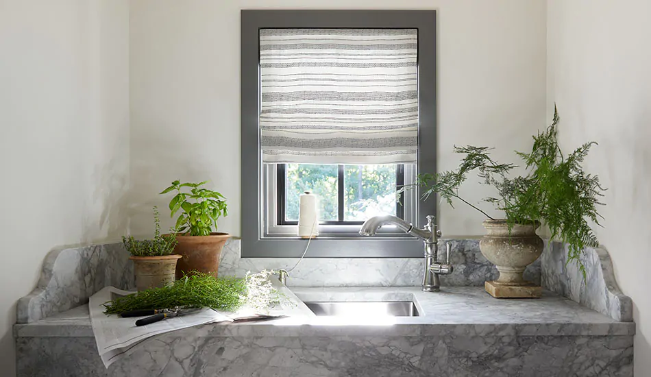 Off-white walls and a light Flat Roman Shades made of Tidal Line in Slate show how to brighten a dark room with light colors