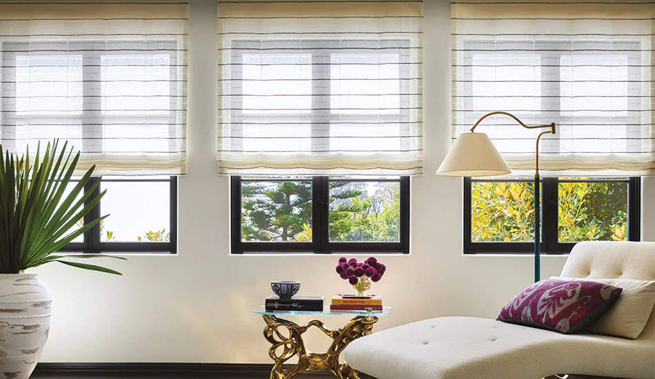 Flat Roman Shades made of Sahara Stripe in Onyx add an airy, simple look to windows in a boho-inspired lounge space