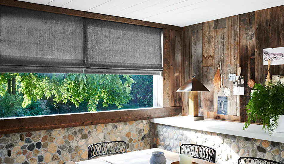 Flat Roman Shades made of Lowell Tweed in Flint are used as an alternative to cat proof blinds in a rustic dining room