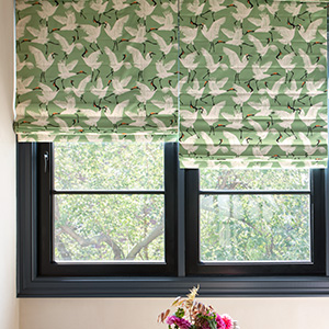 Pull down window shades in the Roman Shade style made of Family of Cranes in Waverly Green offer color to a modern space