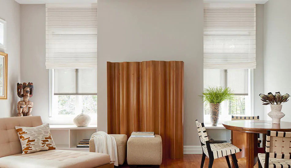 A scandi-chic room has warm wood tones and Roman Shades of Sahara Stripe in Desert over Solar Shades of 3% Thermo in Beige