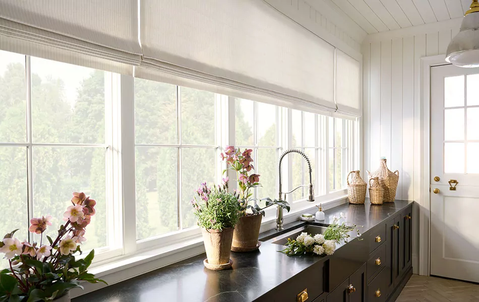 A chic, simple mudroom has Flat Roman Shades made of Ticking Stripe in Dune to contrast the dark cabinets