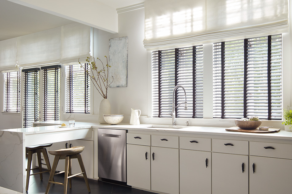 A bright kitchen has two types of blinds, Wood Blinds of Painted Bamboo in Coal and Roman Shades in Tangier Weave, Blanco