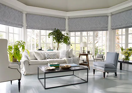 Flat roman shades made from Victoria Hagan's Oceana in Slate adorn a bow window in place of blinds for bay windows
