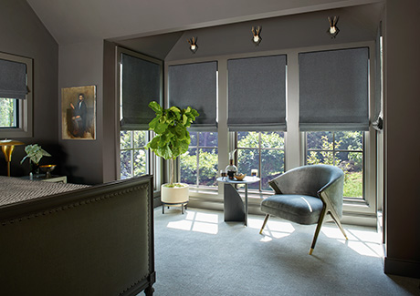 Flat Roman Shades made of Wool Blend in Charcoal with blackout lining cover tall windows in a dark warm grey bedroom