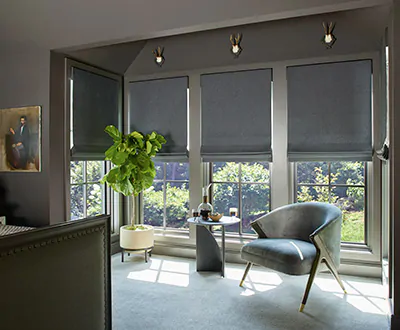 A dark modern bedroom features flat roman shades made from wool sateen in a dark grey