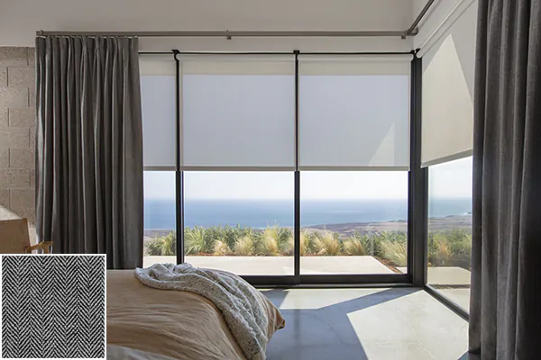 A bedroom with a view has Inverted Pleat Drapery of Herringbone in Onyx for an inviting warm grey color and subtle texture