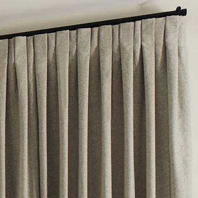 A close up of Inverted Pleat Drapery made of Wool Blend in Fleece shows the crisp pleats for a formal look