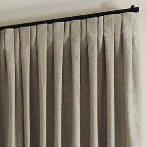 A close up of Inverted Pleat Drapery made of Wool Blend in Fleece shows the crisp, flat pleats of this style