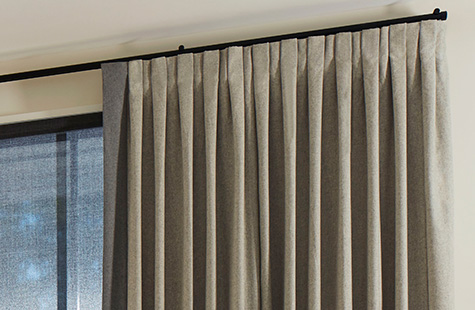 A close up of Inverted Pleat Drapery made of Wool Blend in Fleece shows the crisp folds of this style