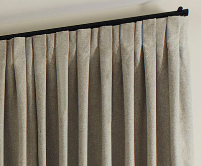 A close up of Inverted Pleat Drapery made of Wool Blend in Fleece shows the flat, crisp pleats for a stately look