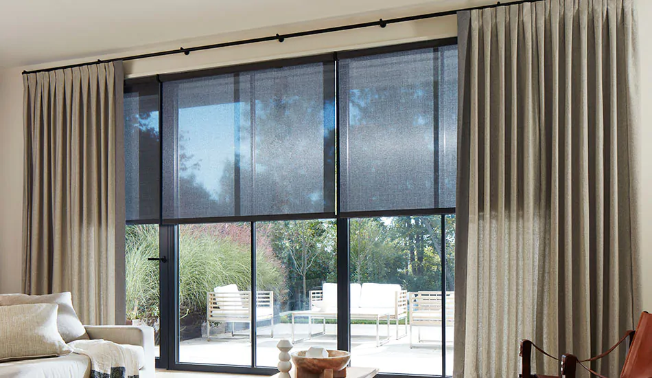 A living room with neutral colors features Inverted Pleat Drapery made of Wool Blend in Fleece for a warm grey backdrop