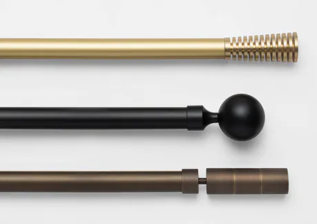 Close-up of three Madison track systems with various finials and colors, including black, gold and bronze