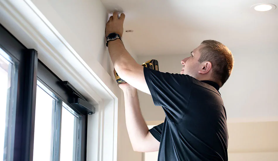 An install professional marks where to place the curtain rod brackets as part of the steps for how to install drapes