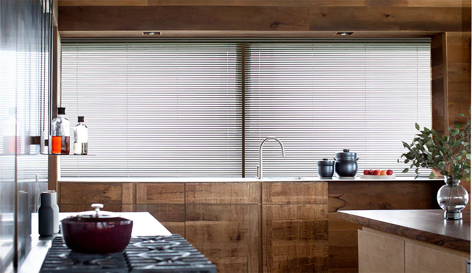 Small window blinds made of 1-inch Metal in Silver add a metallic element to a mid-century modern kitchen