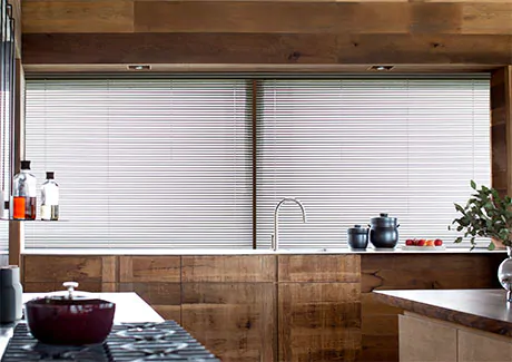 A mid-century-modern kitchen shows the result of learning how to measure for blinds with Metal Blinds over wide windows