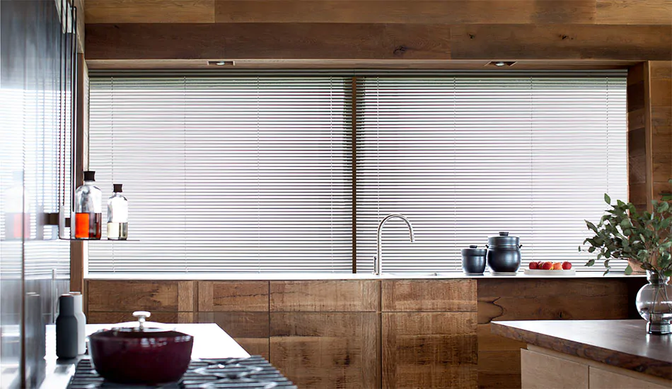 A mid-century modern kitchen with wood tones features colored window blinds made of 1-inch Metal in Silver for contrast