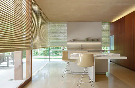 Metal Blinds made of 2-inch Champagne are used as window treatments for large windows in a modern kitchen