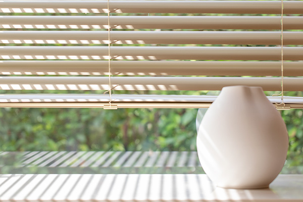 Bathroom window privacy for a bright bathroom is achieved with Metal Blinds made of 2-inch Metal in Champagne