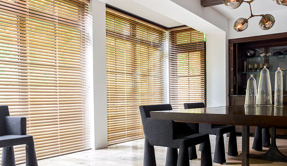 Types of blinds include Metal Blinds made of 2-inch Metal in Champagne over tall windows in a modern dining room