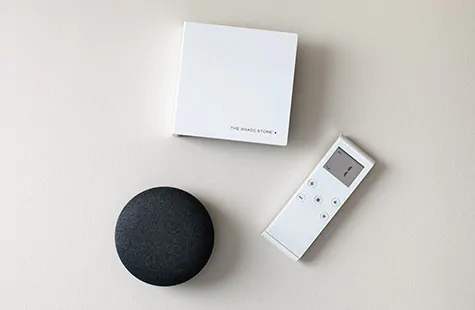 Product shot of a smart home device, a remote control and a wireless link used to link a motorized system to a smart device