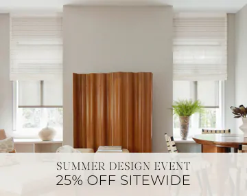 Motorized Roman and Roller Shades hang in a family room with wood decor with sales messaging for Summer Design Event 25% Off