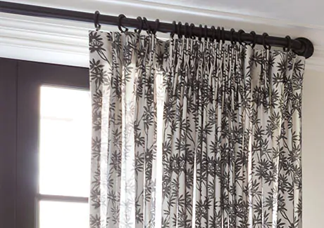 A close up of Pinch Pleat Drapery made of Daisy Bloom in Zebra Black shows a classic pleat design with a modern material