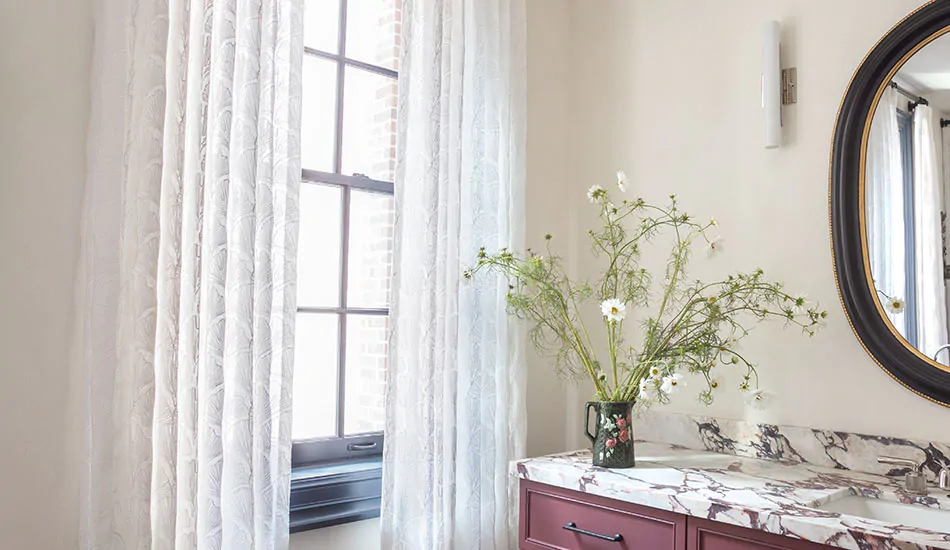 A boho-inspired bathroom features Pinch Pleat Drapery made of Feather Palm Embroidery in Lace for a delicate look