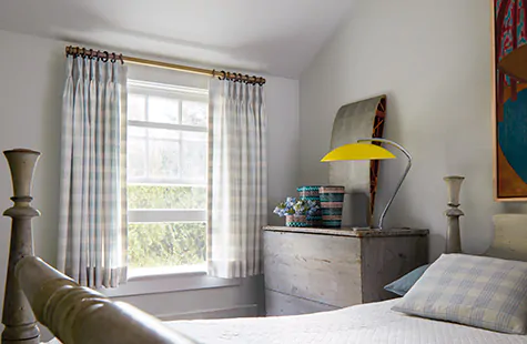 A bedroom has drapery hung just above the window hanging to the sill showing how to measure for curtains at sill length