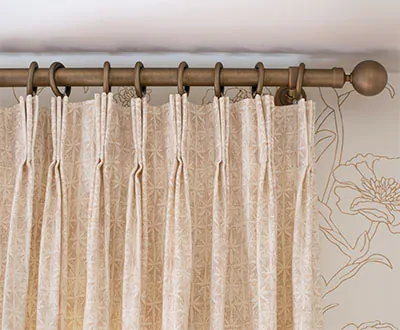 A close up of Pinch Pleat Drapery made of Paloma in Sandstone shows the 3-finger pleats pinched 4 inches from the top