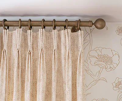 Boho curtains made of Pinch Pleat Drapery of Paloma, Sandstone offer another layer of texture to a room with floral wallpaper