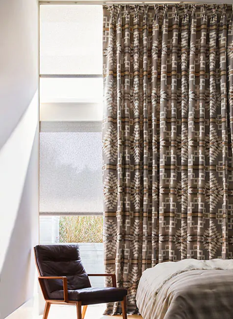 A tall window has Pendleton curtains made in the Pinch Pleat Drapery style with Zapotec in Terra material