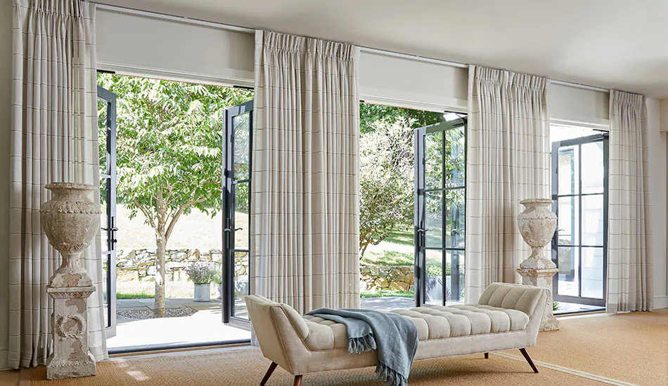 French door window treatments include Pinch Pleat Drapery made of Sankaty Stripe in Sand on tall, wide doors in a living room