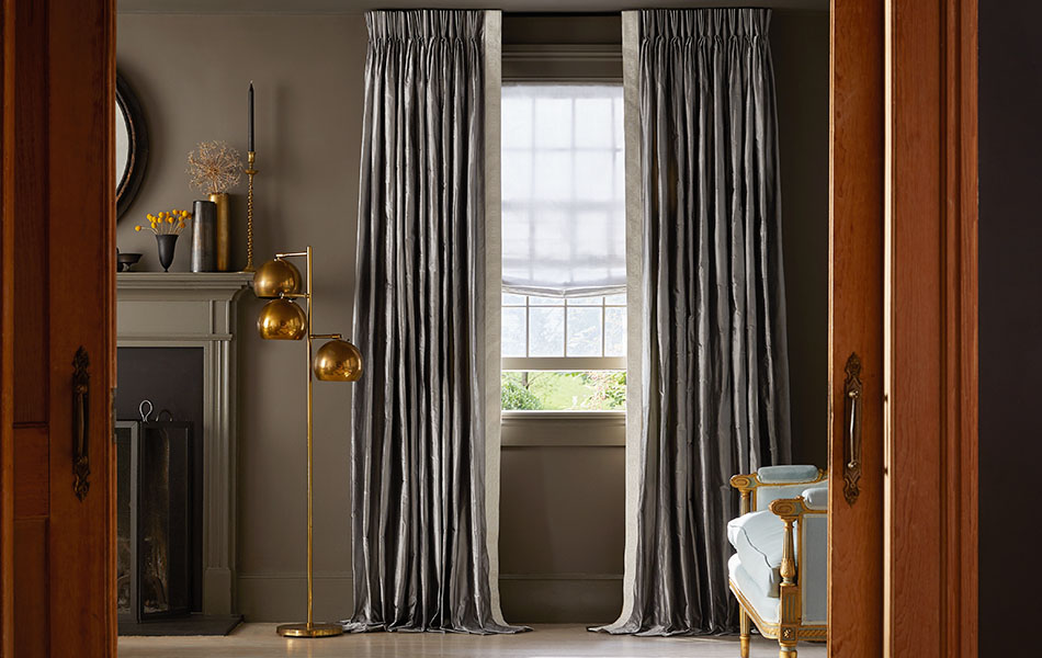 Pinch Pleat Drapery in Silk Dupioni Pewter in a luxe living room, showing how long curtains should be for puddle length.