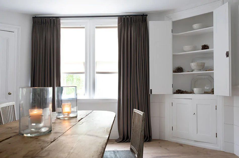 Dark gray drapery made of Wool Flannel in Walnut hung in a rustic kitchen shows the result of learning how to install drapes