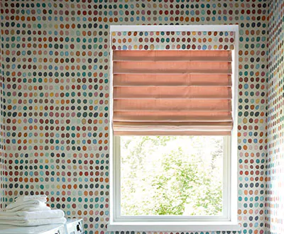 A laundry room features a Pleated Roman Shade with an upholstered valance in a polka dot pattern that matches the wall decals