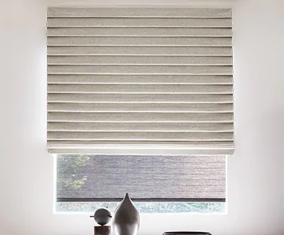 A Pleated Roman Shade made of Wool Blend in Fleece adds drama to the window in an otherwise minimalist, modern room