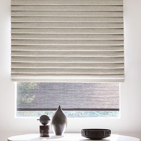 A Pleated Roman Shade made of Wool Blend in Fleece delivers unexpected elegance to a stark, minimalist sitting room