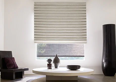 A pleated Roman Shade made of Woold Blend in Fleece adds a luxe look to a window in a modern reading nook