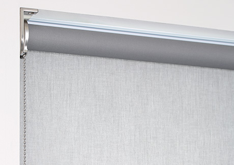 A product image of a regular roll roller shade shows the material falling off the back of the tube closer to the window