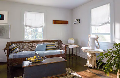 Relaxed Roman Shades made of Windsor Stripe in Sage deliver a soft, casual look to a coastal-inspired sitting room