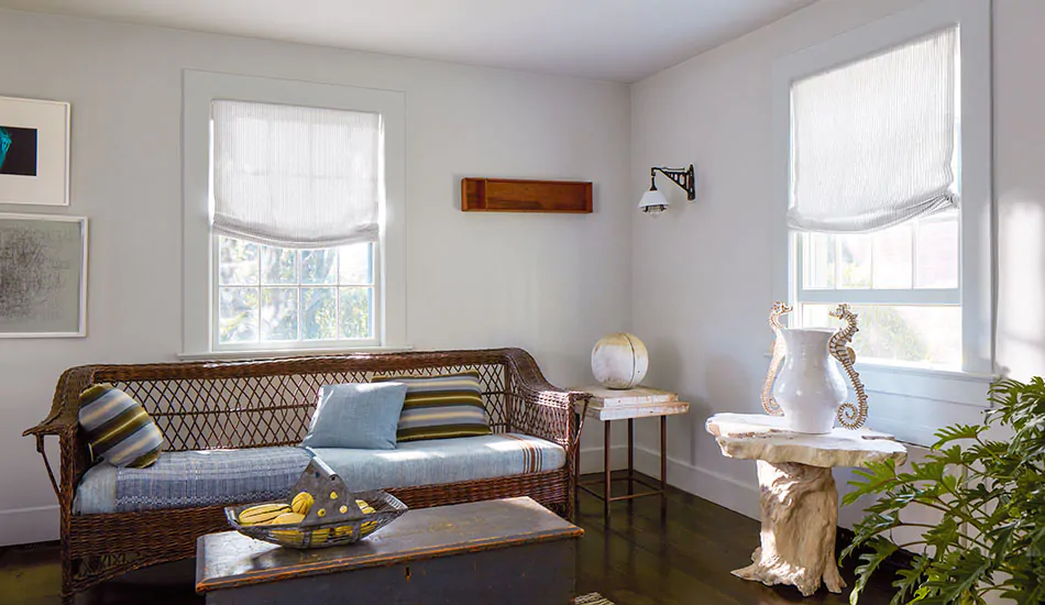 A coastal inspired sitting room features Relaxed Roman Shades in Windsor Stripe in Sage for a subtle pinstripe design