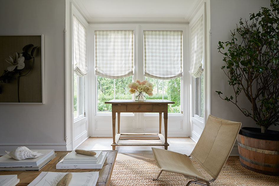 Breakfast nook with relaxed Roman shades in patterned fabric, showing different types of shades for windows with soft, decorative styling