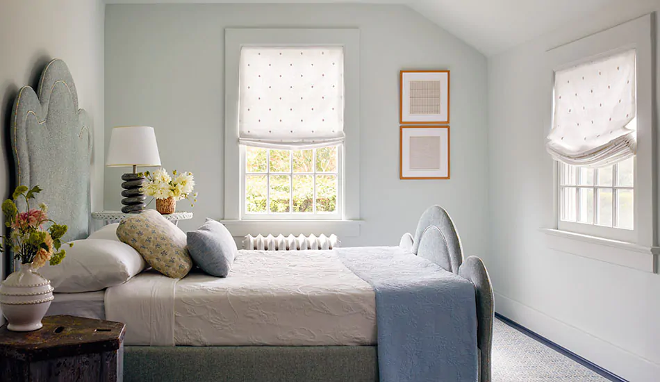 Roman shades for windows include Relaxed Roman Shades made of Celeste in Moon in a cozy cottage-inspired bedroom