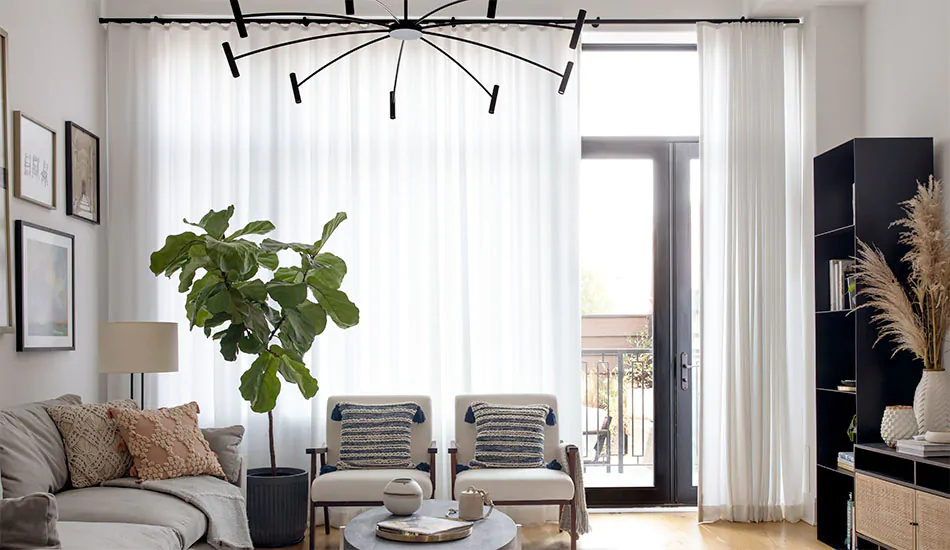 A contemporary living room features white and black elements as well as curtain sheers made of Basket Sheer in Winter