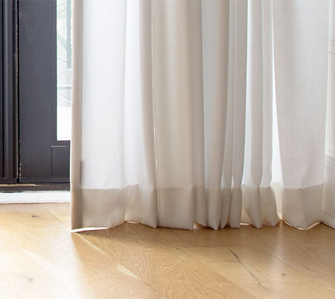 The bottom of Ripple Fold Drapery in Basket Sheer, Winter, floats above the floor which is more common for drapes vs curtains