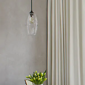 A close up of a hanging glass light fixture shows one easy tip for how to brighten a dark room with the right fixtures