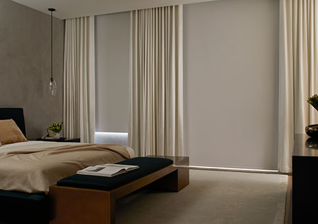 Window coverings in a modern bedroom include Ripple Fold Drapery made of Canvas in Natural and Roller Shades in Cora, White