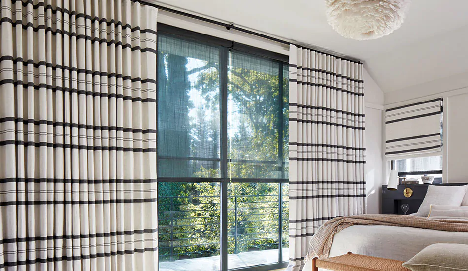 A bold bedroom shows modern curtain ideas in its high contrast Ripple Fold Drapery made of Shoreham Stripe in Jet