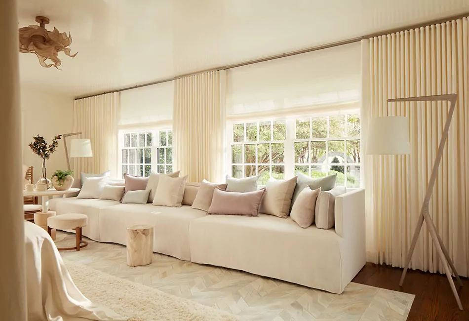 From the couch to the ripple fold drapes, this cream-colored monotone look provides more living room curtain ideas